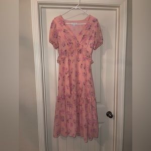 Pink floral dress with puff sleeves and tie bow in front.